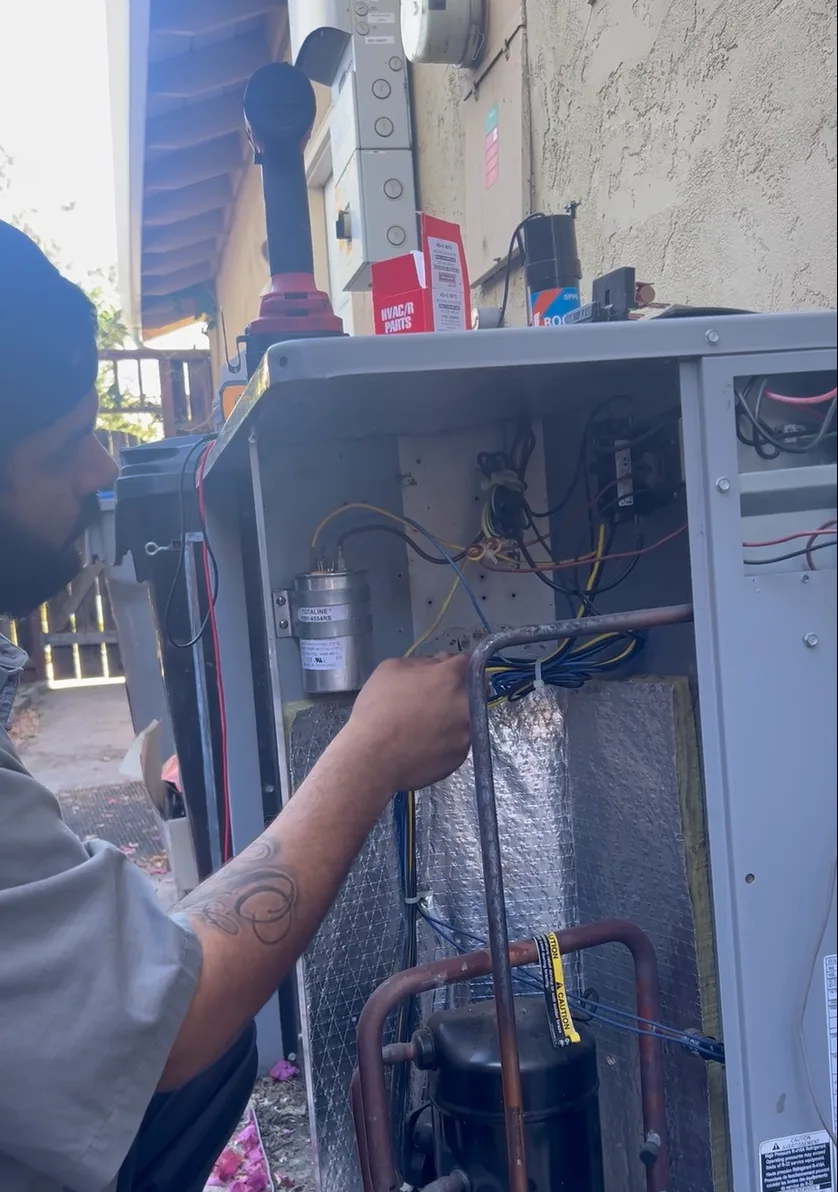 Technician working in the electrical compartment of an outdoor air conditioning unit in Almaden, San Jose