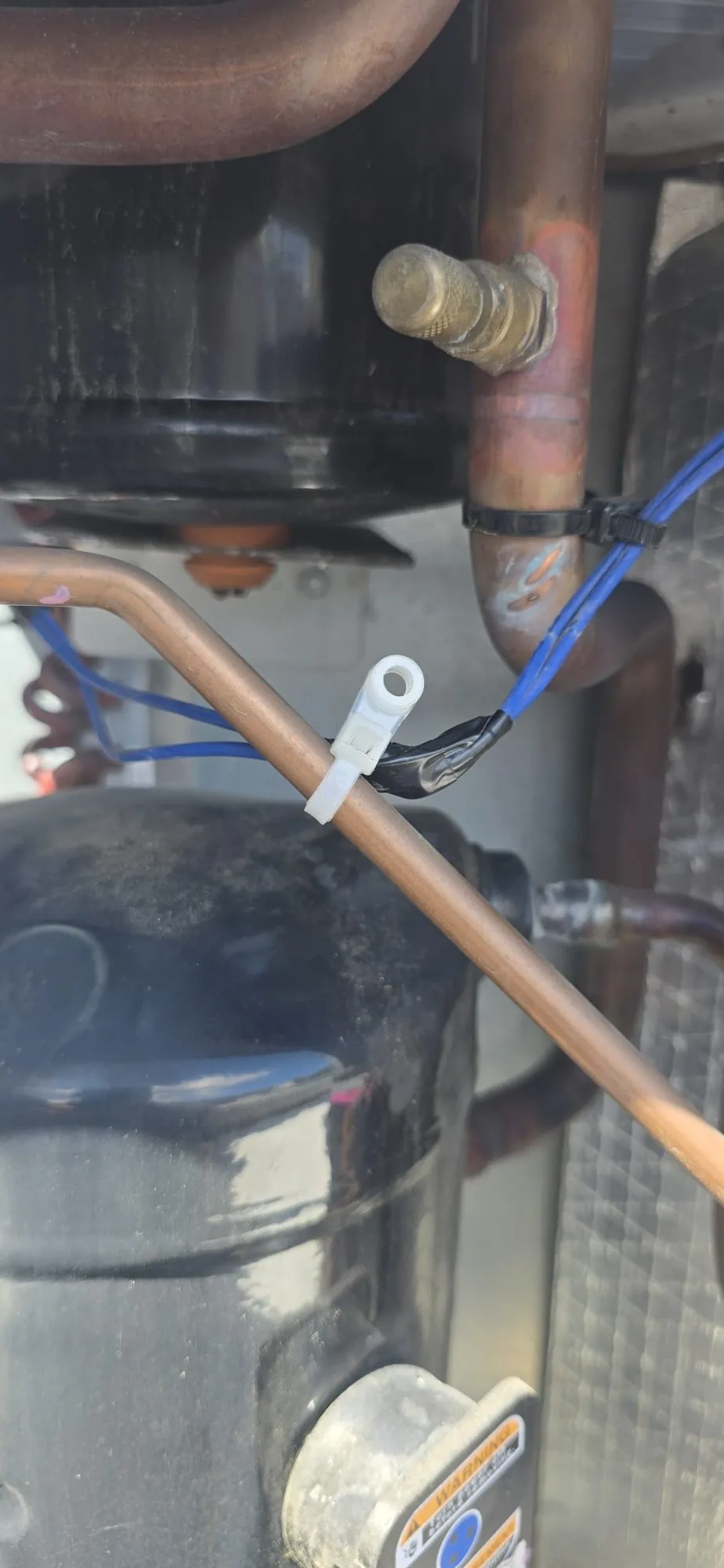 Compressor compartment with copper refrigerant lines and secured wiring on a rooftop package unit