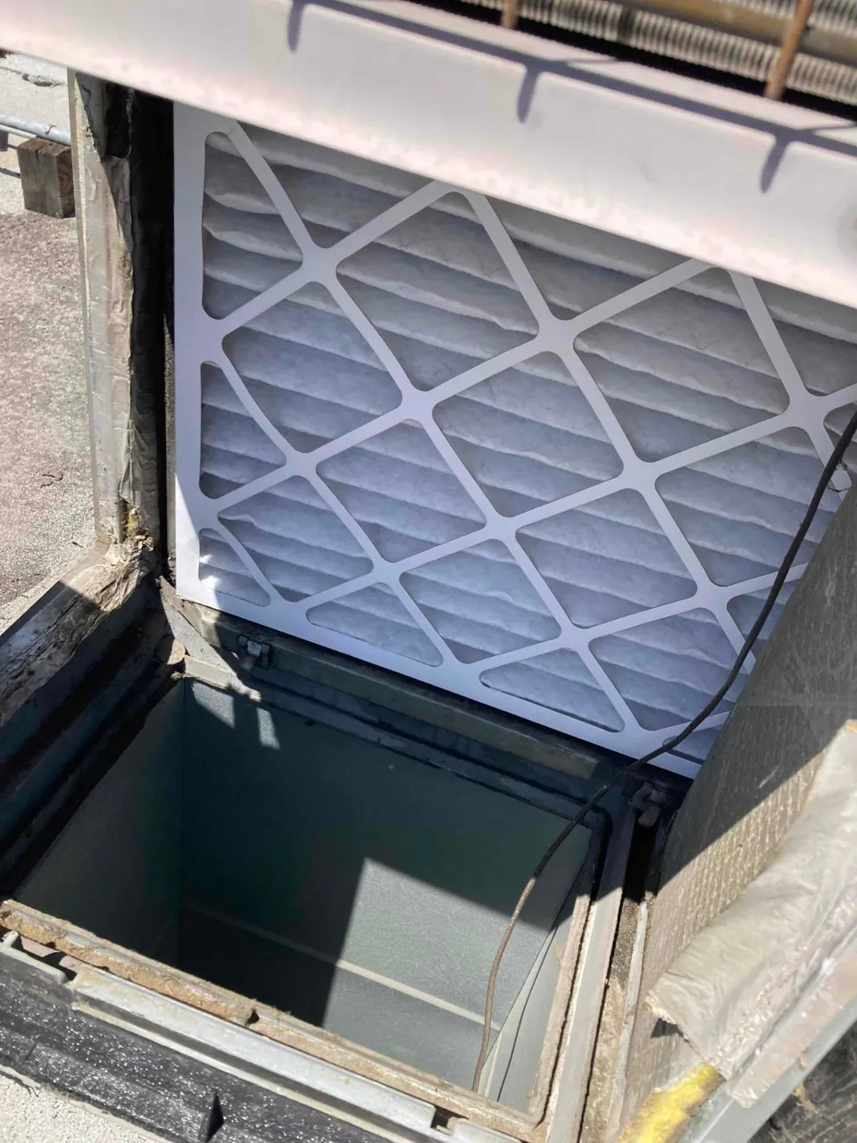 New pleated air filter installed in a rooftop package unit at a commercial building in Santa Clara CA 95050