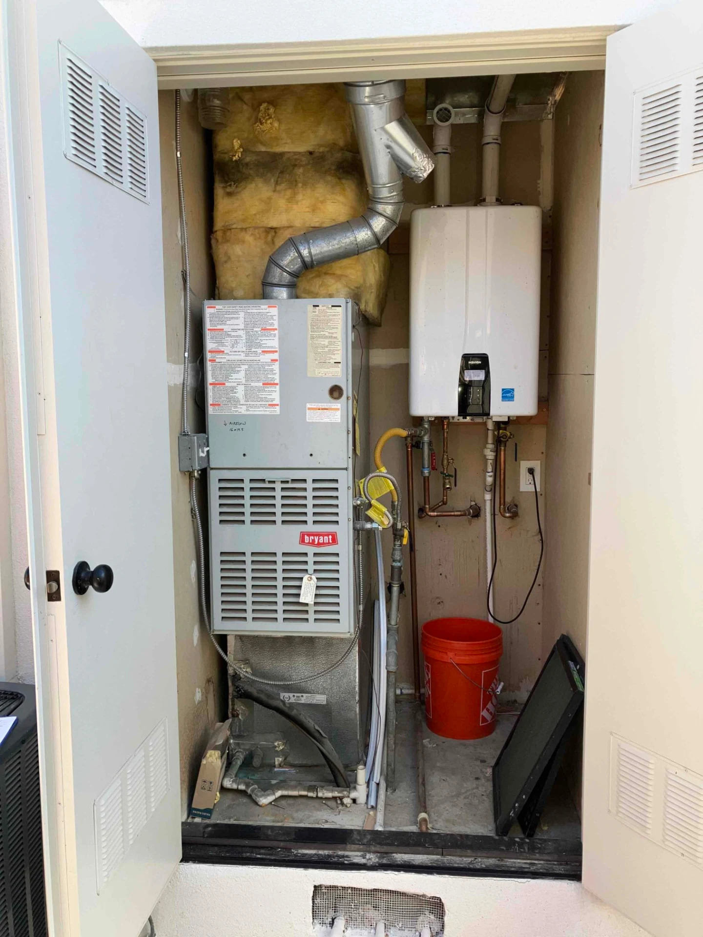 Older Bryant indoor HVAC equipment in a utility closet