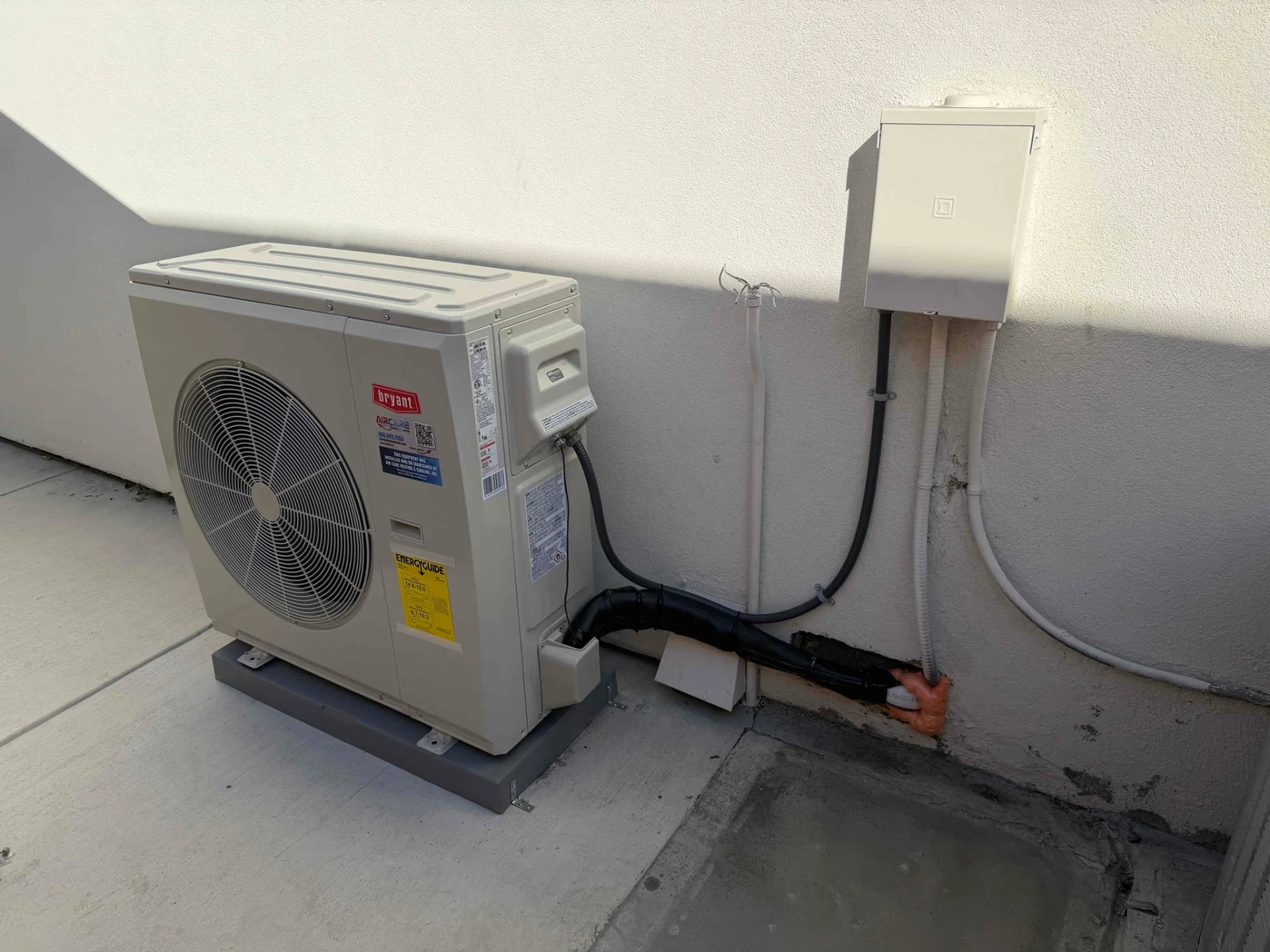 Bryant outdoor HVAC unit beside a stucco wall and electrical box