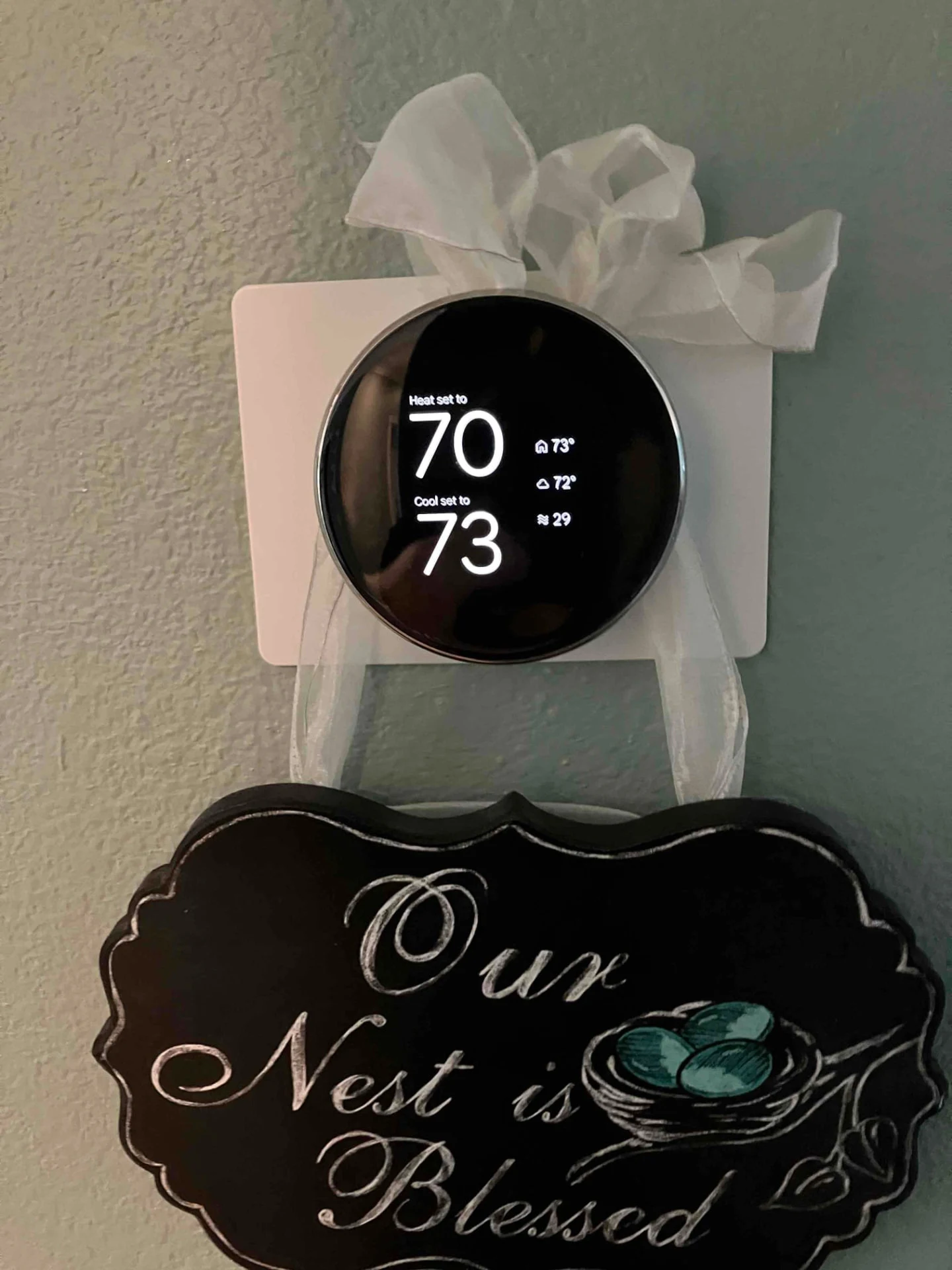Round wall thermostat displaying heating and cooling settings