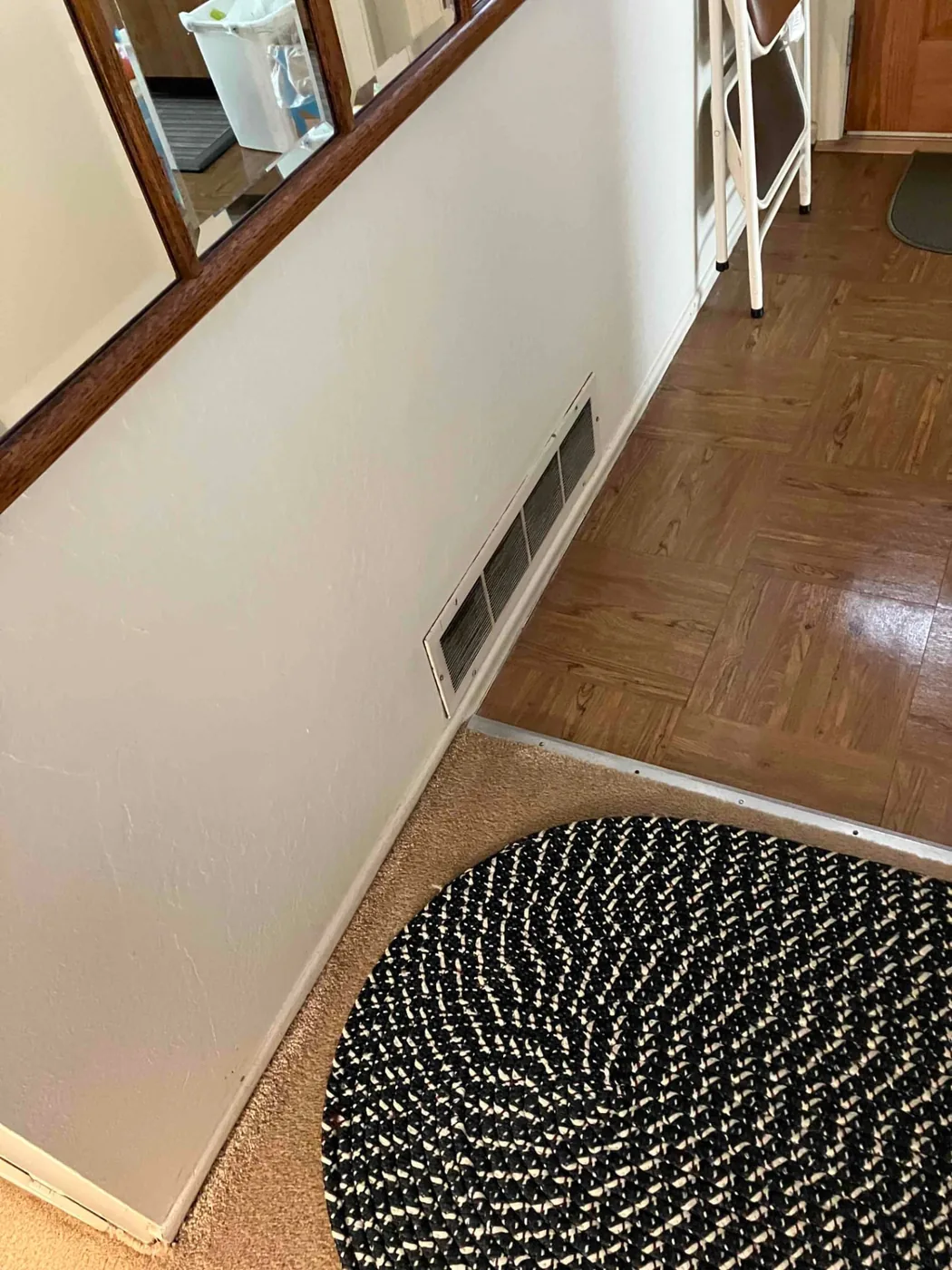 Return-air grille low on a hallway wall before the furnace replacement in Mountain View, CA 94040