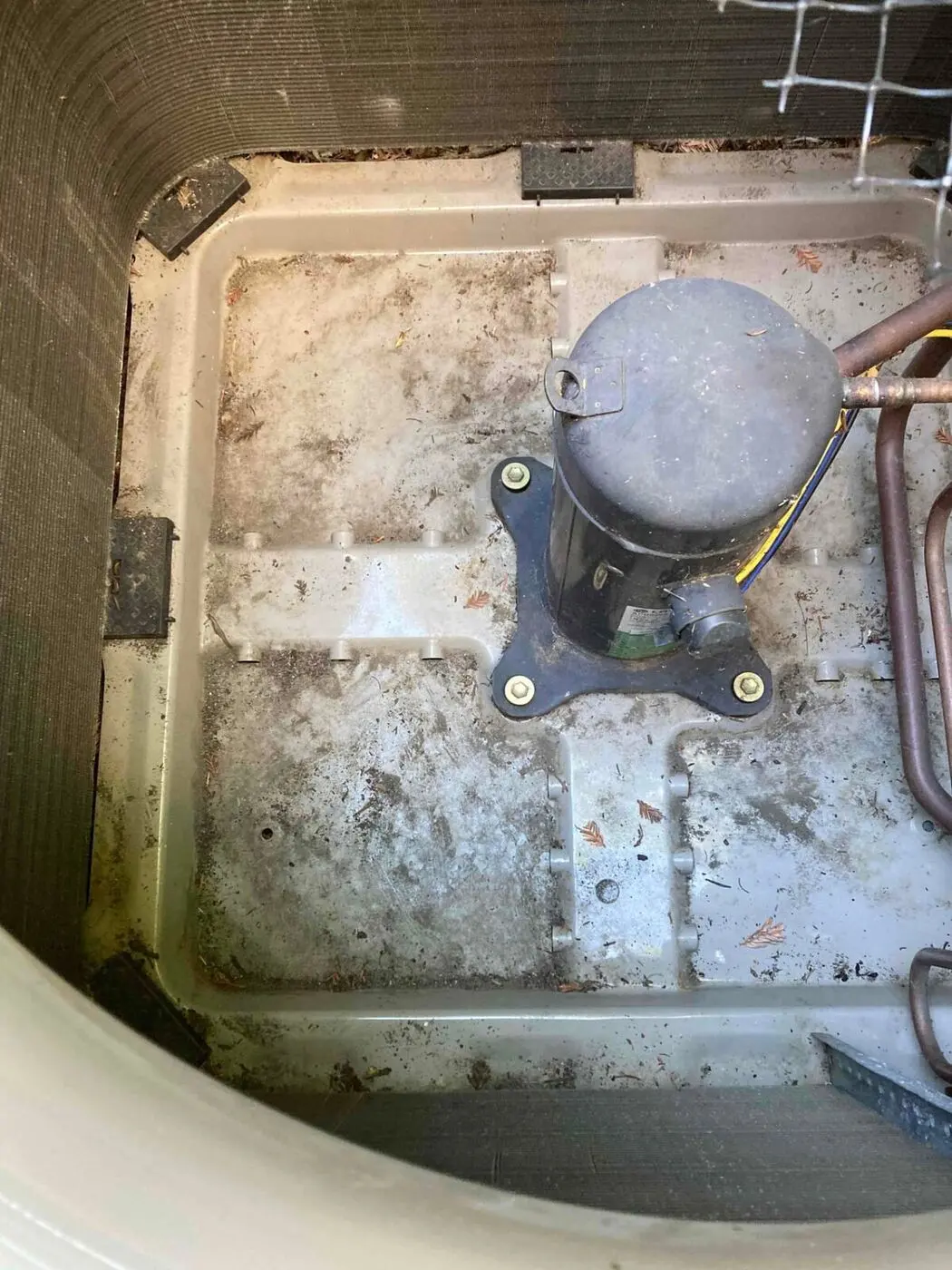 Base pan inside the outdoor condensing unit after debris was cleaned out