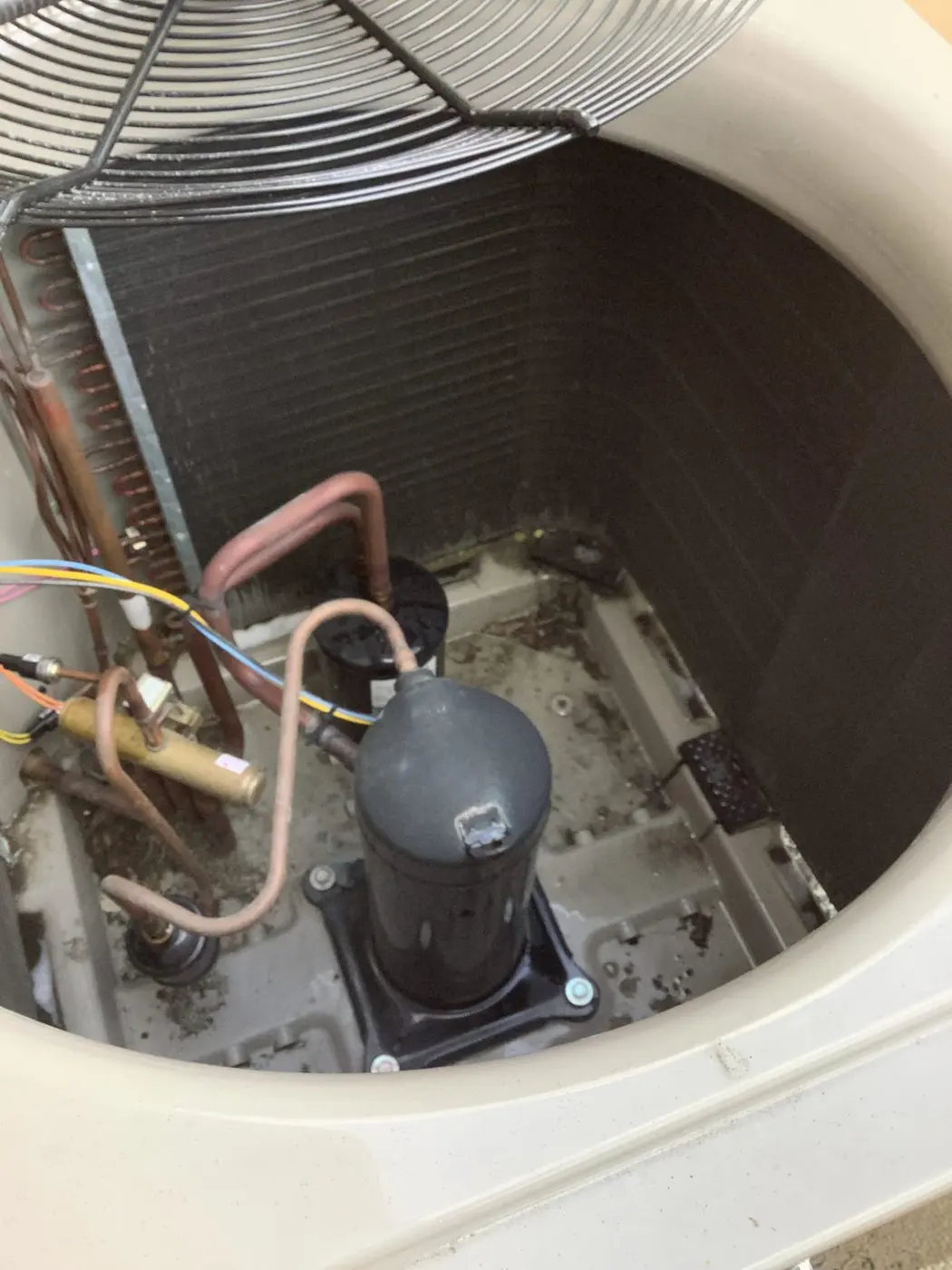 Interior of an outdoor heat pump unit showing the compressor and condenser coil in Santa Clara, CA 95051