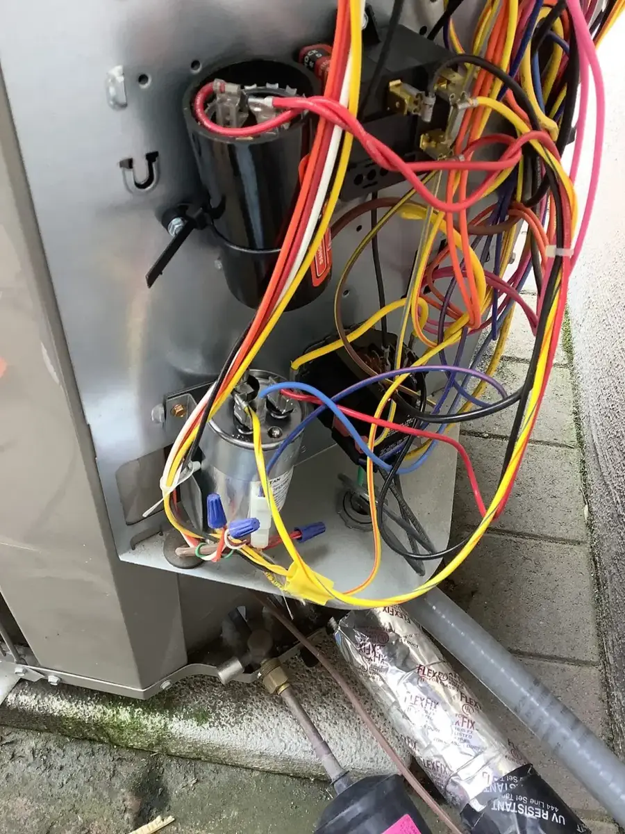 Open electrical compartment of an outdoor heat pump unit showing capacitors, contactor, and wiring in Santa Clara, CA 95051