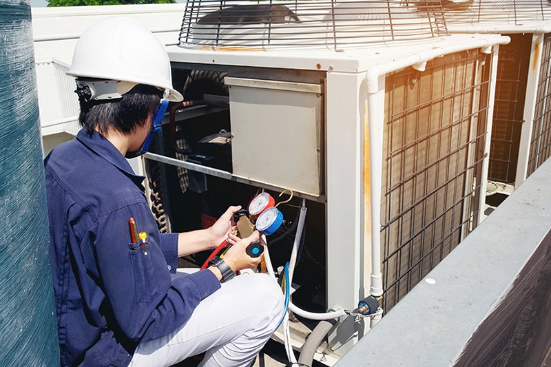 Why Is a Commercial AC Tune-Up Important? A technician working on a commercial air conditioner.